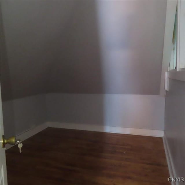 bonus room featuring vaulted ceiling, baseboards, and wood finished floors