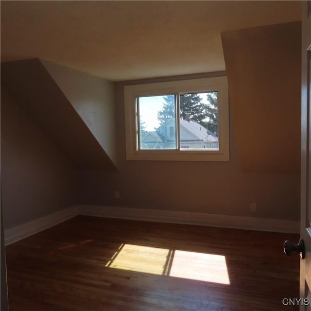 bonus room featuring baseboards and dark wood-style flooring