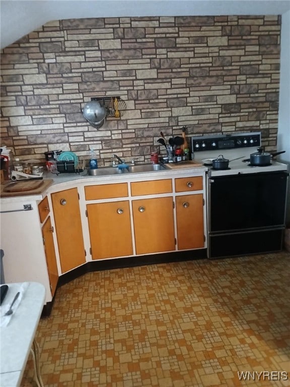 kitchen with a sink, tasteful backsplash, light countertops, and electric stove