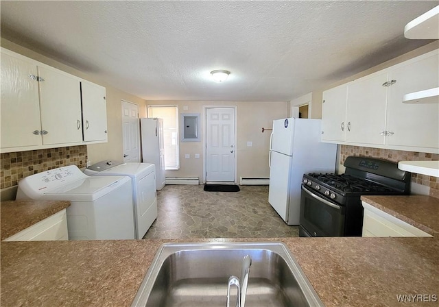 kitchen featuring gas stove, a baseboard radiator, washing machine and clothes dryer, a sink, and backsplash