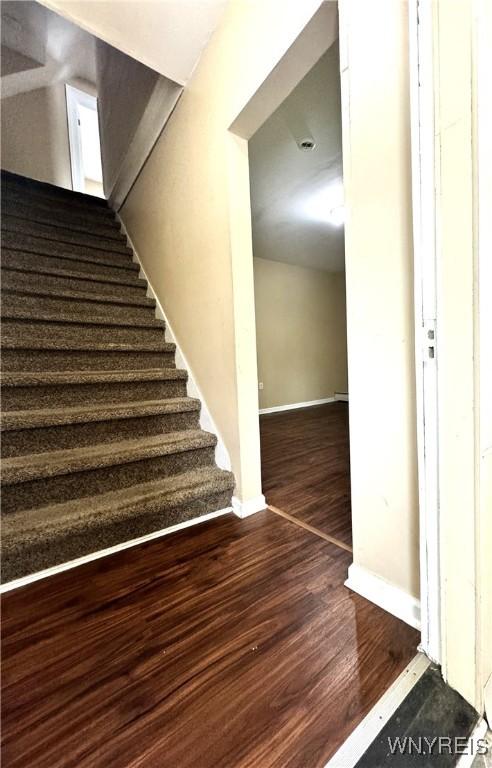 stairs with wood finished floors and baseboards