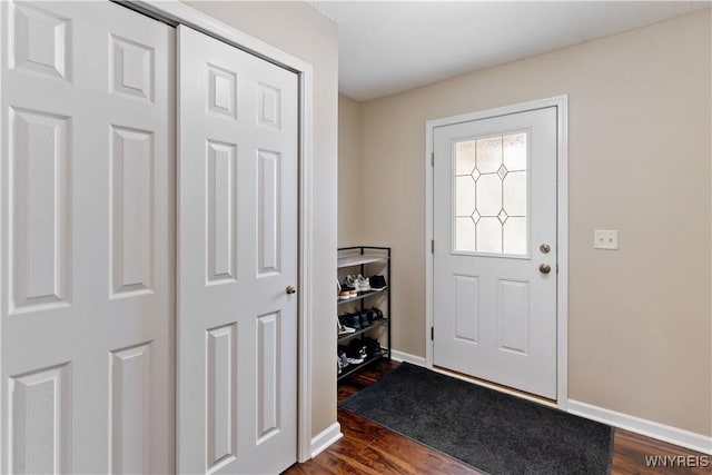 entrance foyer with dark wood-type flooring and baseboards