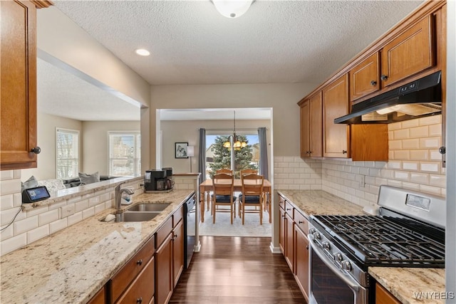 kitchen featuring a sink, under cabinet range hood, dishwasher, gas range, and brown cabinets