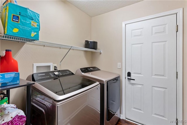 clothes washing area with laundry area, independent washer and dryer, and a textured ceiling