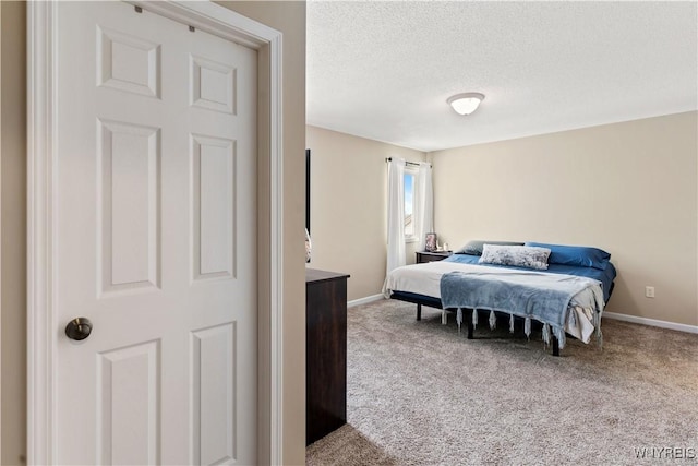 bedroom featuring baseboards, a textured ceiling, and carpet