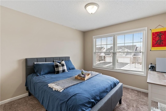 bedroom featuring carpet, baseboards, and a textured ceiling