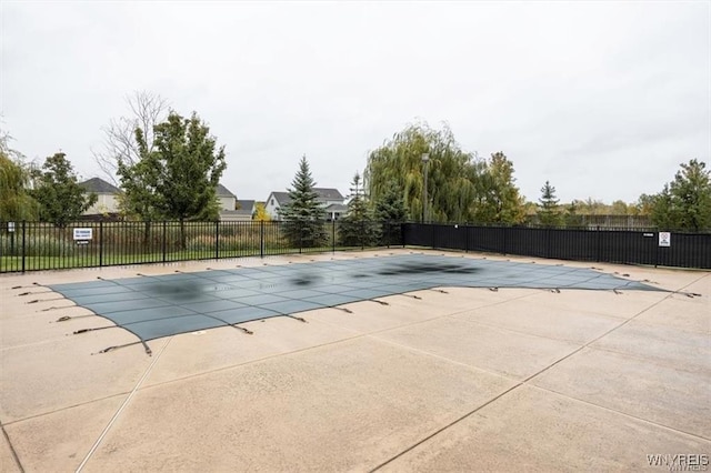 community pool with a patio and fence