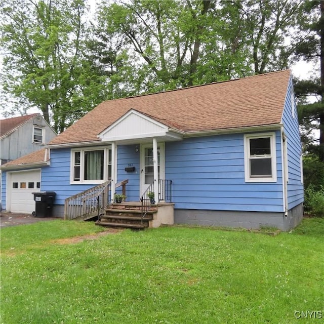 view of front of home with a garage, a front yard, and a shingled roof