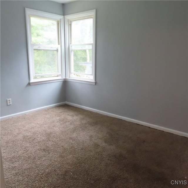 unfurnished room featuring baseboards and carpet