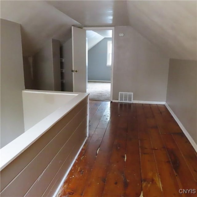 bonus room featuring visible vents, baseboards, hardwood / wood-style floors, and vaulted ceiling