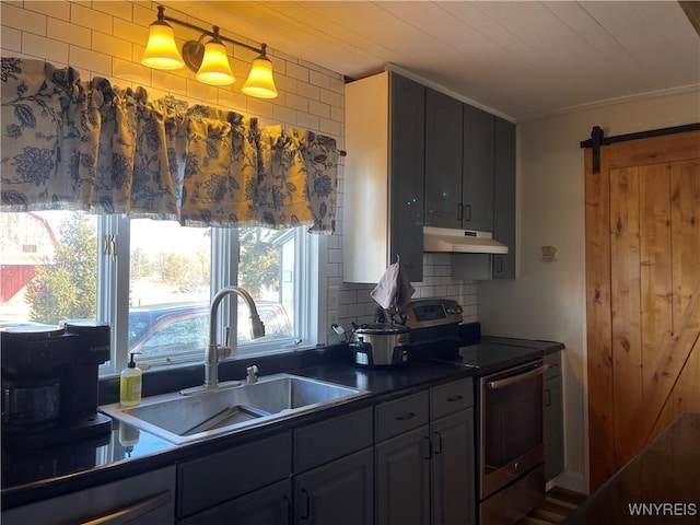 kitchen with dark countertops, a sink, stainless steel range with electric cooktop, under cabinet range hood, and a barn door