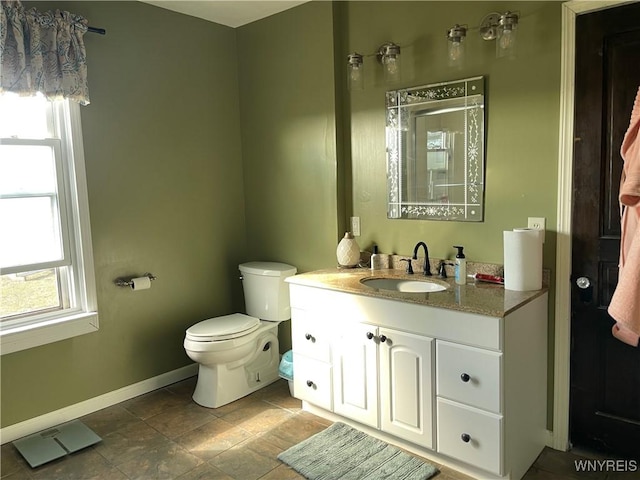 bathroom with a shower, baseboards, toilet, and vanity