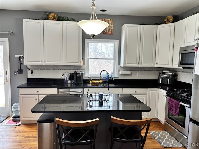 kitchen featuring white cabinets, stainless steel appliances, and light wood-style floors