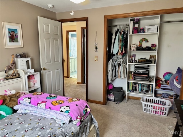 carpeted bedroom featuring a closet and baseboards