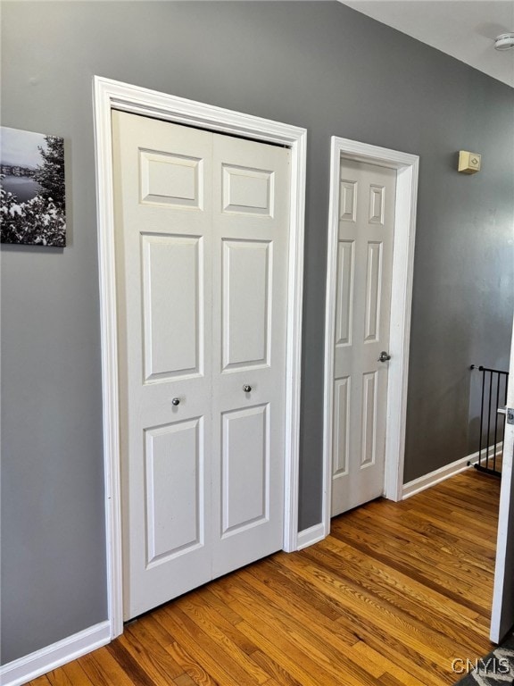 unfurnished bedroom with a closet, baseboards, and wood finished floors