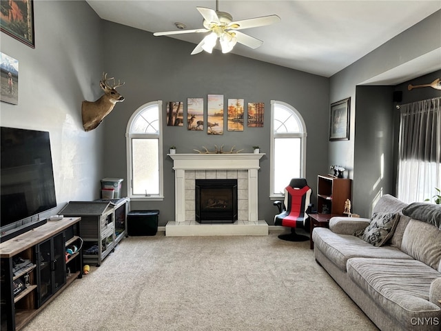 carpeted living room featuring a ceiling fan, vaulted ceiling, and a fireplace