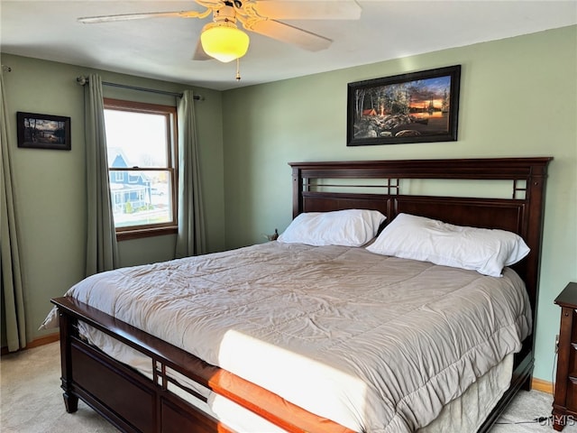 bedroom with light colored carpet, baseboards, and a ceiling fan