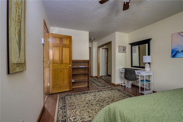 bedroom featuring a textured ceiling, a ceiling fan, baseboards, and wood finished floors