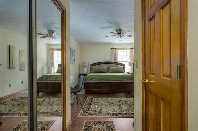 bedroom featuring a textured ceiling, ceiling fan, and wood finished floors