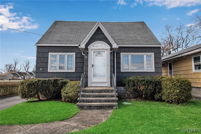 bungalow-style house with roof with shingles and a front yard