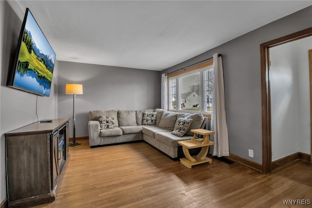 living room with light wood-type flooring and baseboards