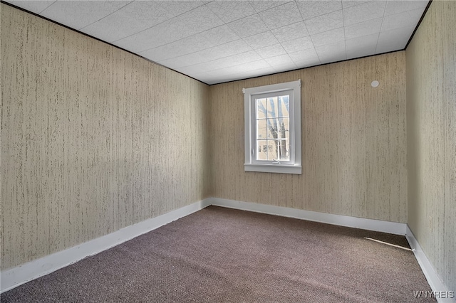 carpeted spare room featuring baseboards