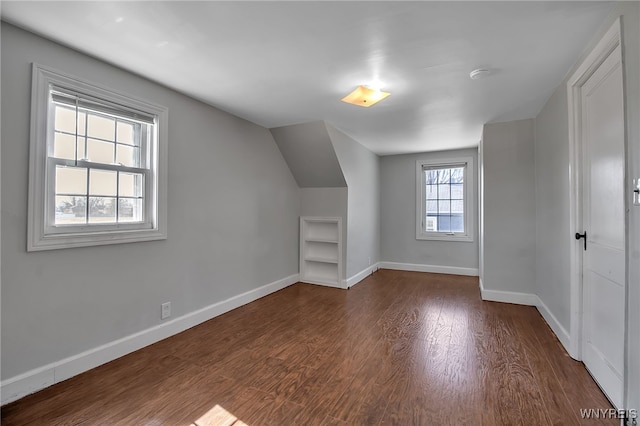 additional living space with lofted ceiling, wood finished floors, and baseboards