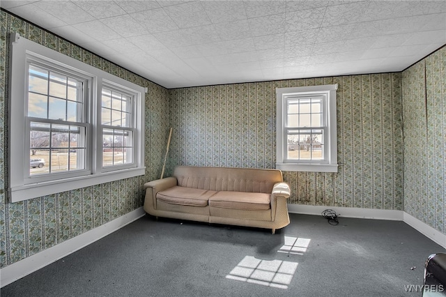 sitting room with wallpapered walls, baseboards, and a wealth of natural light