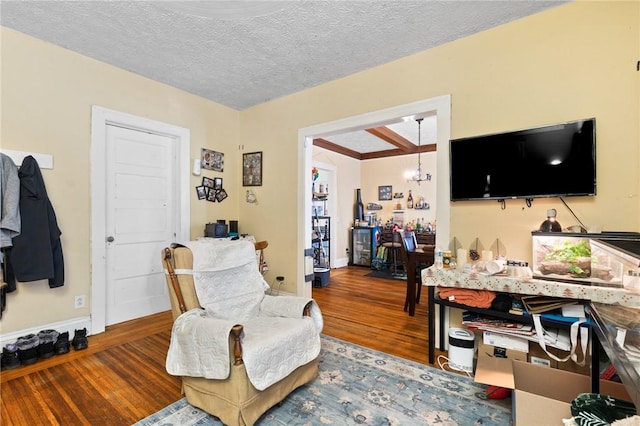 sitting room featuring an inviting chandelier, a textured ceiling, baseboards, and wood finished floors