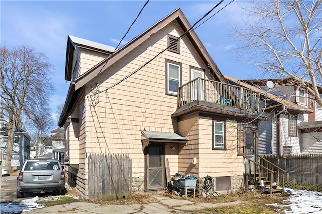 rear view of property with a balcony and fence