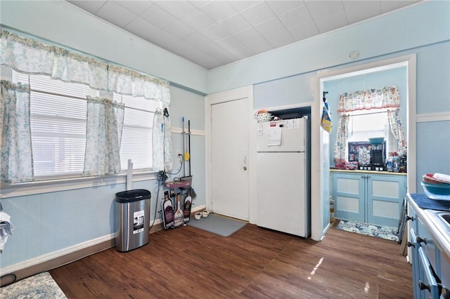 interior space featuring dark wood-style flooring and freestanding refrigerator