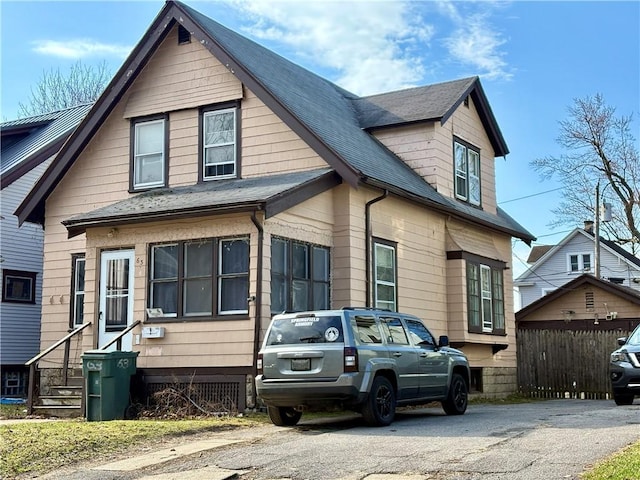 view of front of home featuring fence, roof with shingles, and entry steps