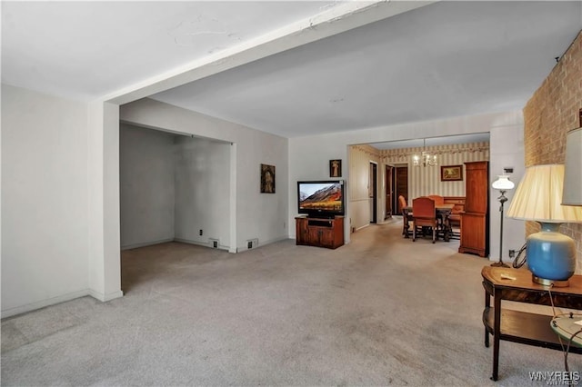 carpeted living room with baseboards and a chandelier