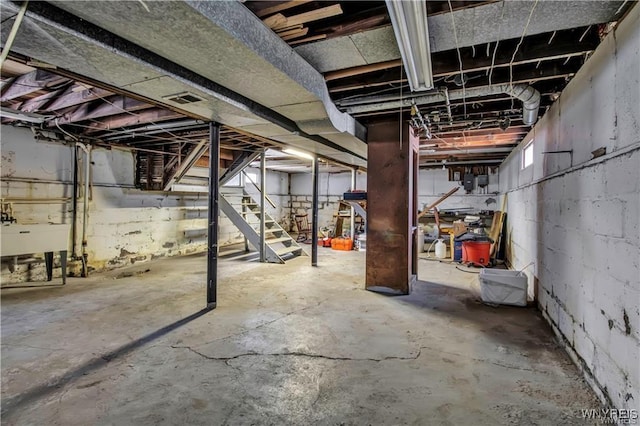 unfinished basement with a sink and stairway