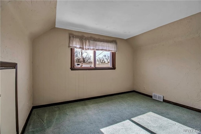 additional living space featuring visible vents, baseboards, lofted ceiling, and carpet