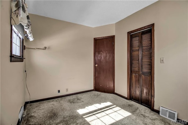 unfurnished bedroom featuring visible vents, carpet floors, and baseboards