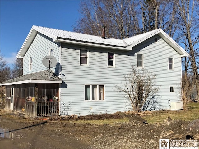 view of side of property with a sunroom and metal roof