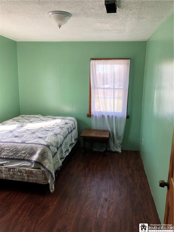 bedroom with wood finished floors and a textured ceiling