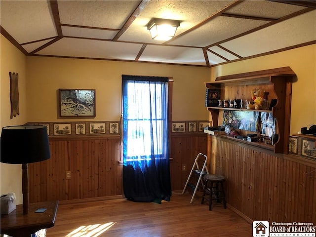 interior space with wooden walls, wood finished floors, and a wainscoted wall