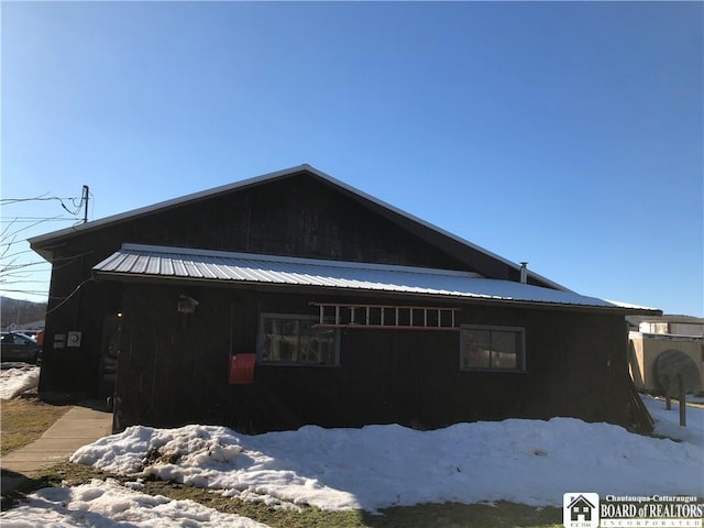 view of snowy exterior with metal roof