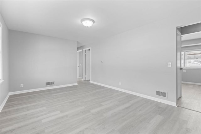 empty room featuring visible vents, baseboards, and light wood-style floors