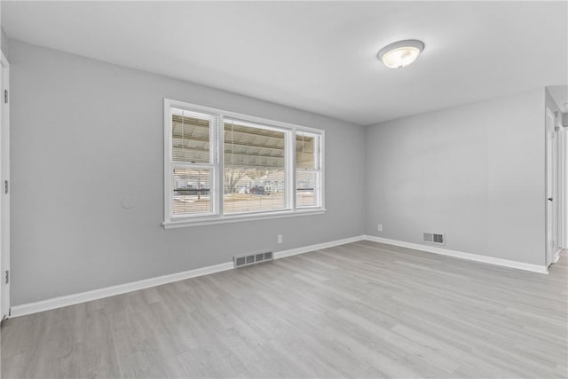 spare room featuring visible vents, wood finished floors, and baseboards