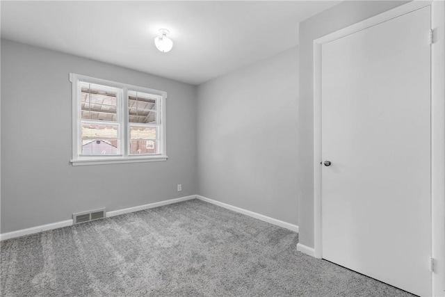 spare room featuring visible vents, baseboards, and carpet flooring