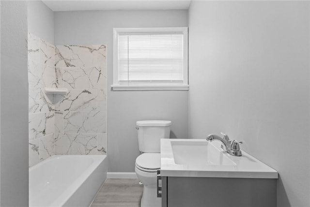 bathroom with vanity, wood finished floors, baseboards, shower / bathing tub combination, and toilet