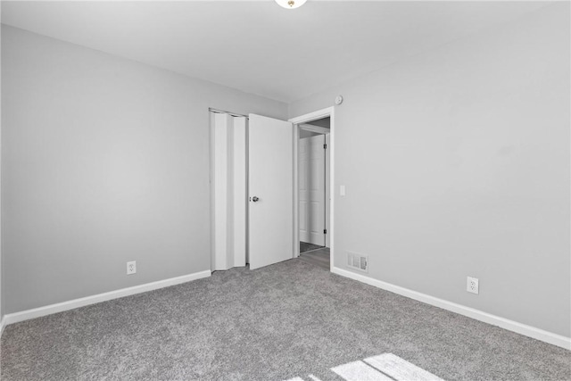 unfurnished bedroom with a closet, visible vents, baseboards, and carpet floors