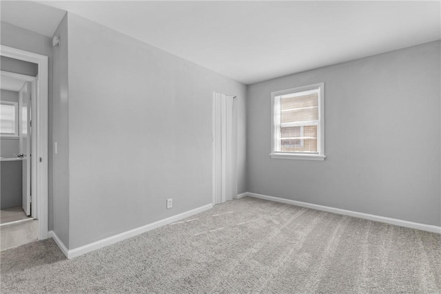 carpeted empty room with baseboards and a wealth of natural light