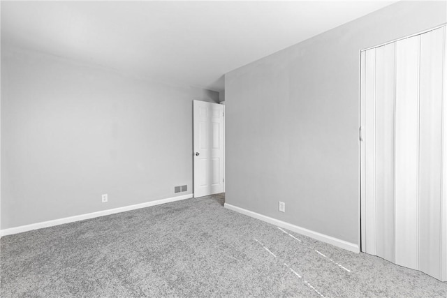 unfurnished bedroom featuring baseboards, carpet floors, and visible vents