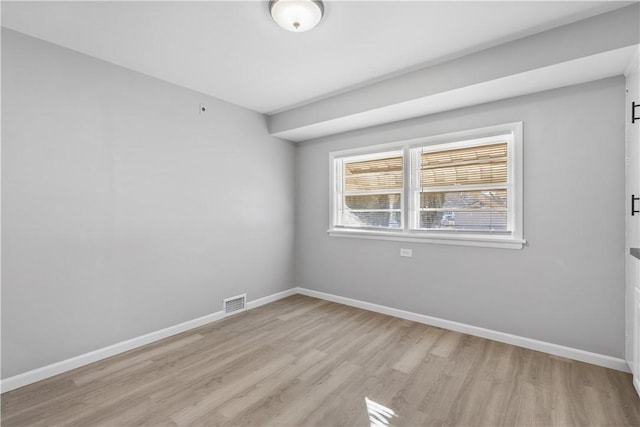 spare room with visible vents, light wood-style flooring, and baseboards