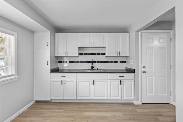 kitchen with dark countertops, light wood-style floors, and a sink