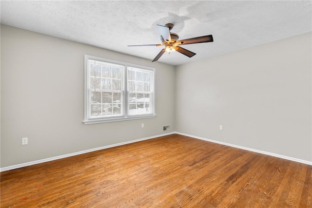 unfurnished room featuring ceiling fan, baseboards, and wood finished floors